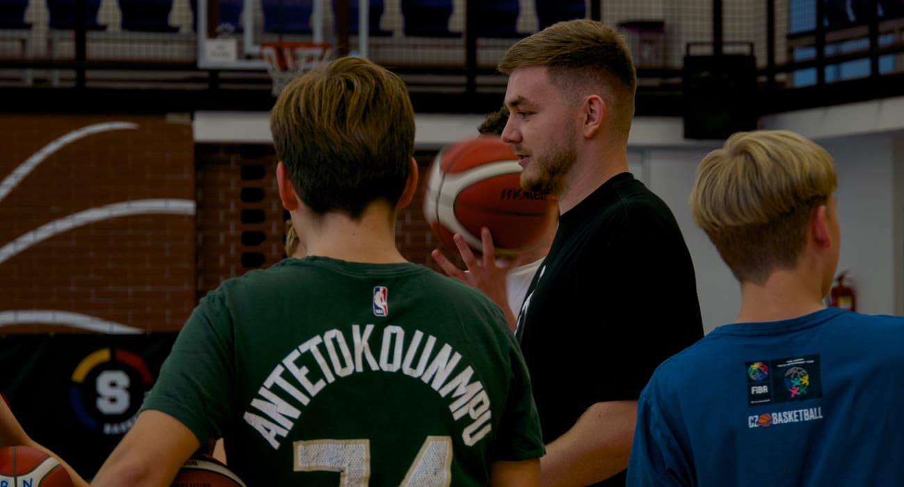 Ondra vysvětluje skupině hráčů cvičení v hale