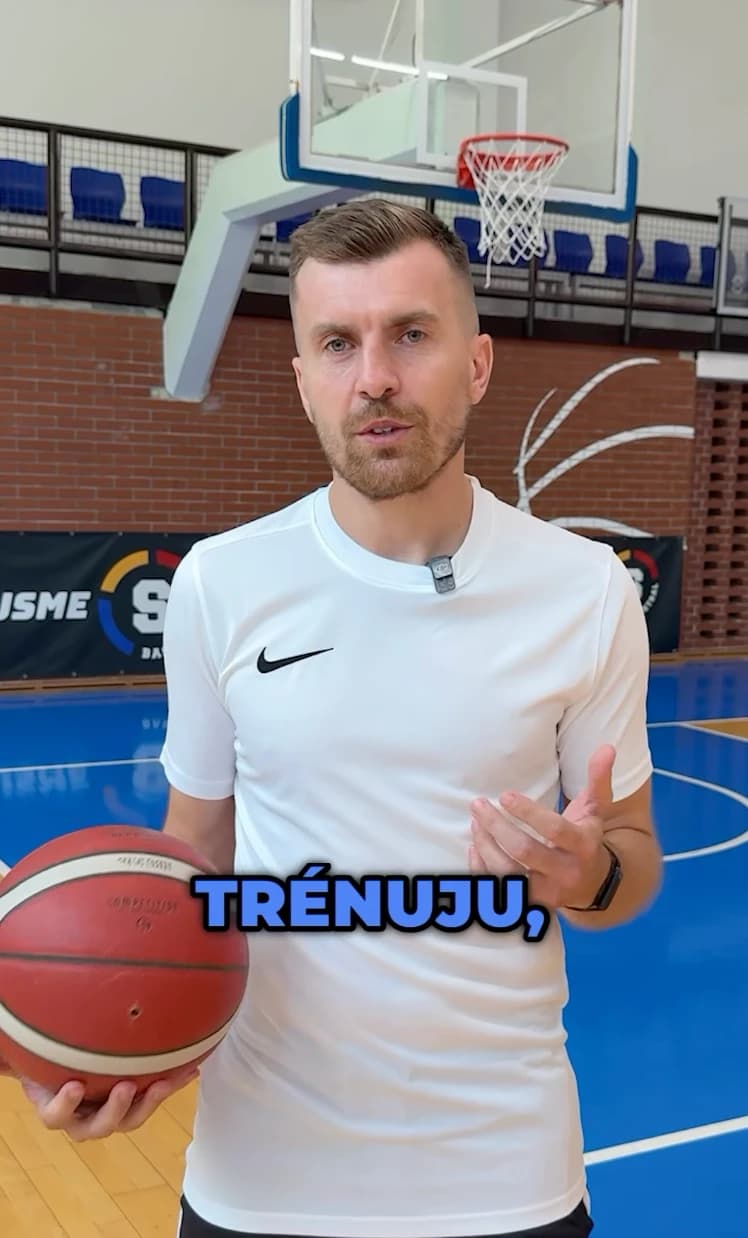 Trenér s míčem na hale vysvětluje, jak vypadá individuální trénink