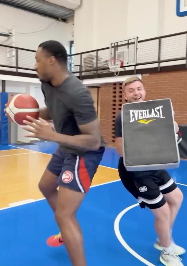 Nácvik zakončení proti kontaktu — trenér brzdí hráče nárazovou deskou